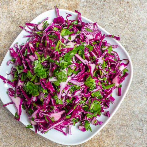 Red cabbage salad on white plate, top down