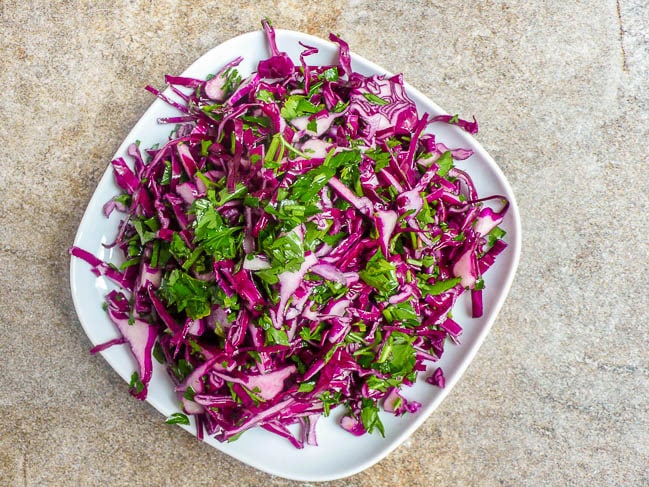 Red cabbage salad on white plate, top down