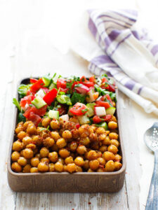 Spiced chickpeas with chopped salad in rectangular bowl, seen from eye level