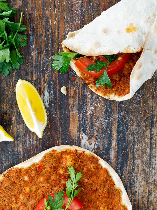 Turkish lahmacun with fresh tomato and parsley, wrapped and ready to eat