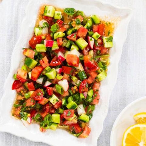 Turkish shepherd salad on rectangular white plate, seen up close and from above