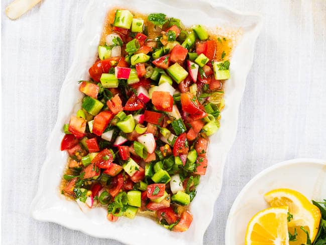 Turkish shepherd salad on rectangular white plate, seen up close and from above