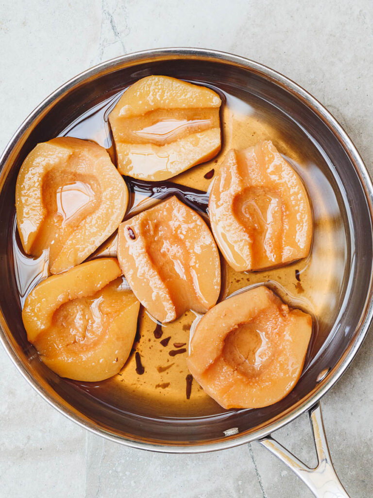 Quinces poached in syrup in their pan, seen from above