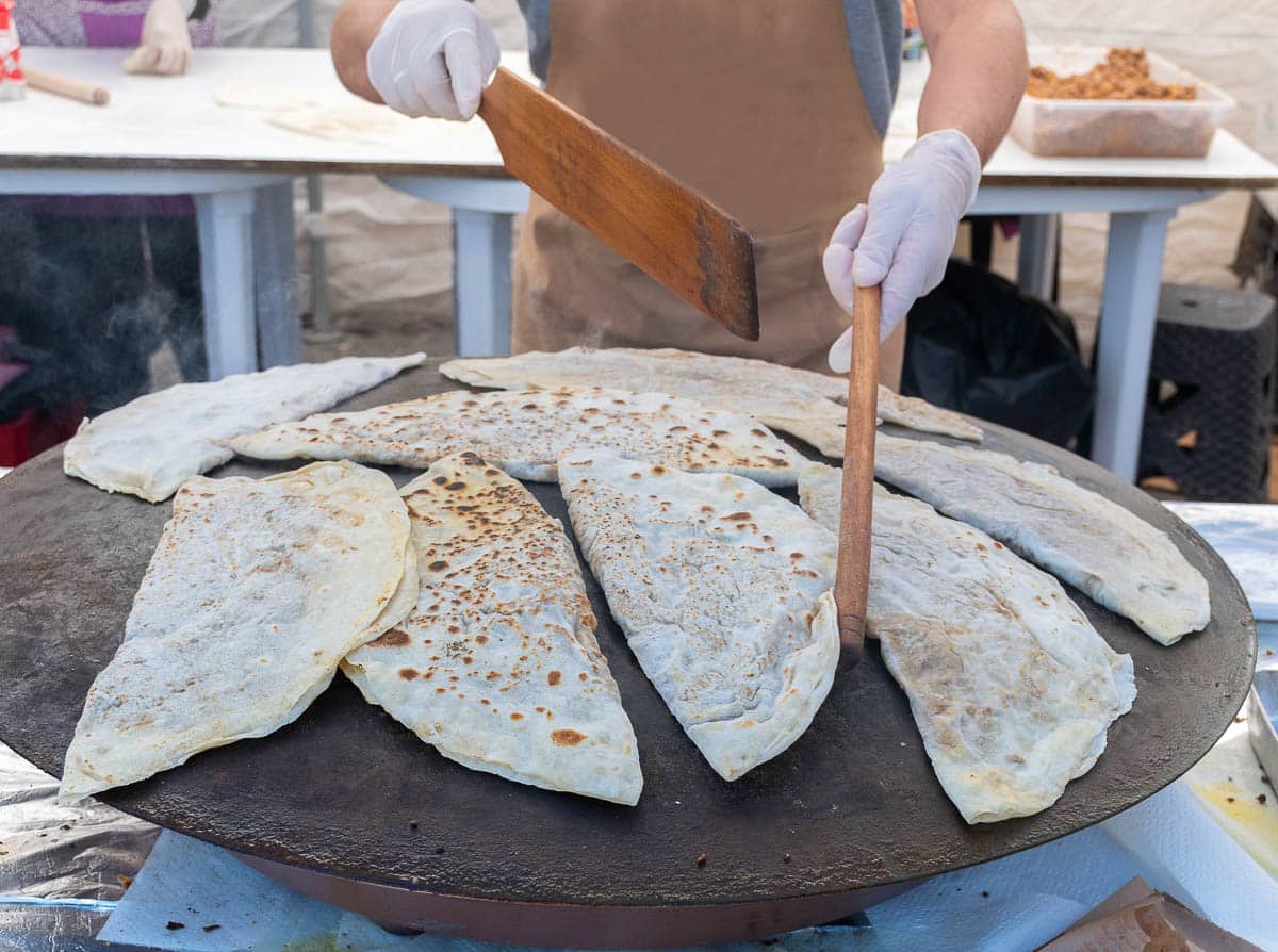 Gözleme being cooked on a Turkish griddle called sac