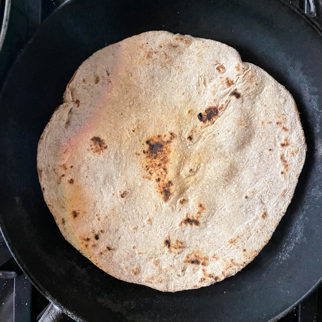 Armenian lavash flatbread cooking in a pan with cooked side up