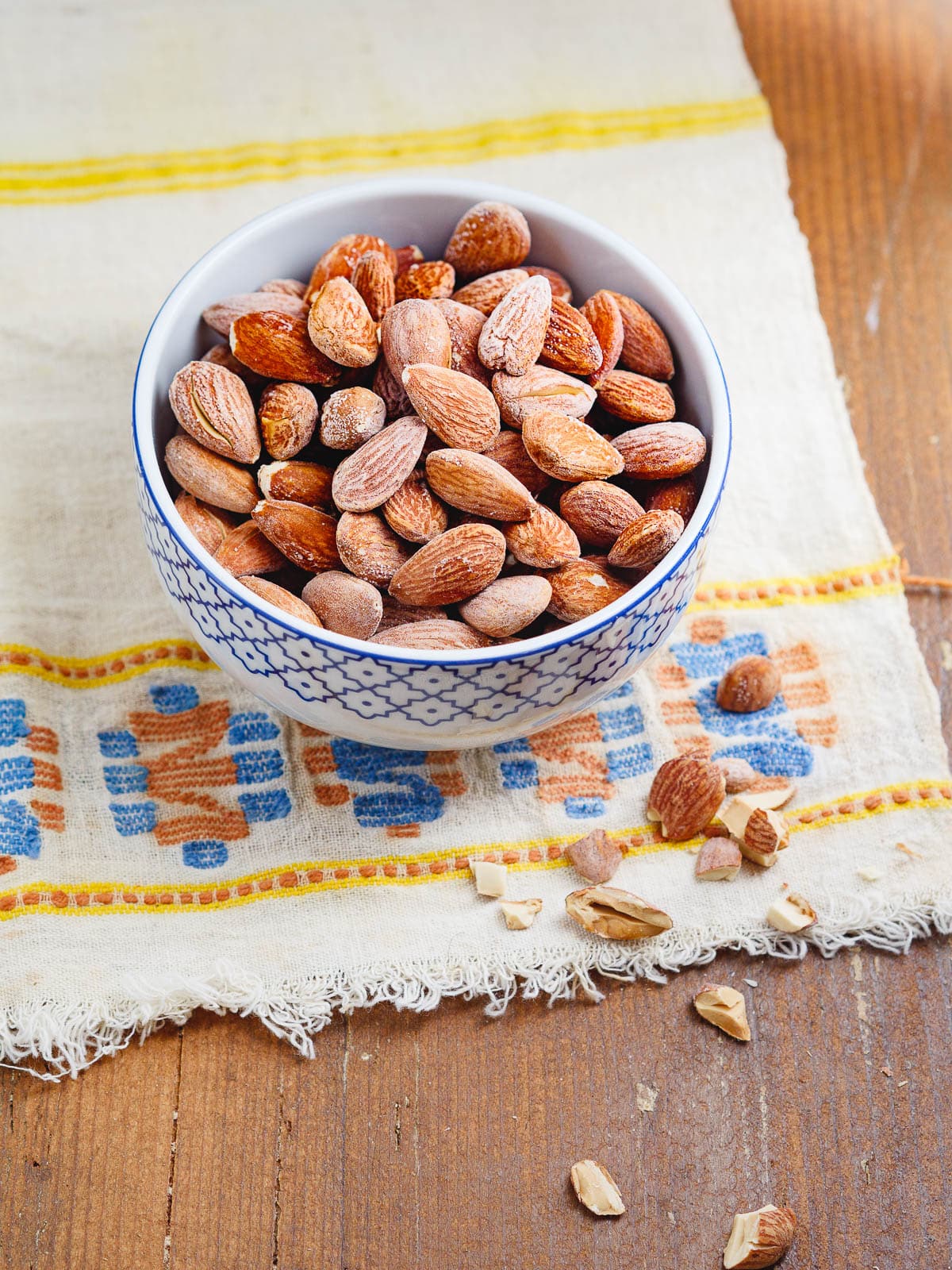 Roasted salted almonds in a small bowl, seen from eye level